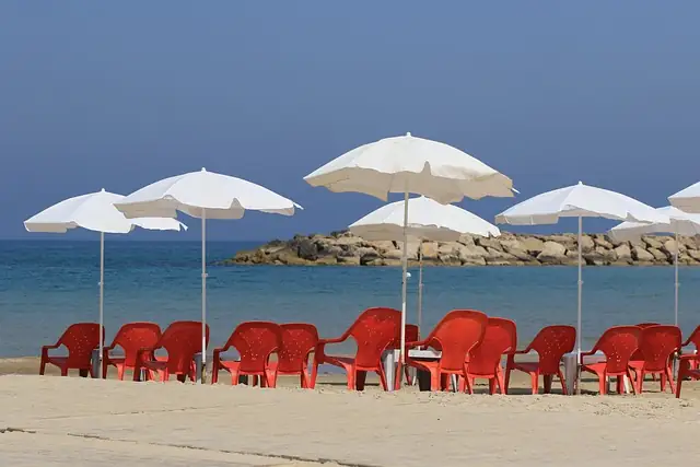 White parasols and red chairs on a quiet beach