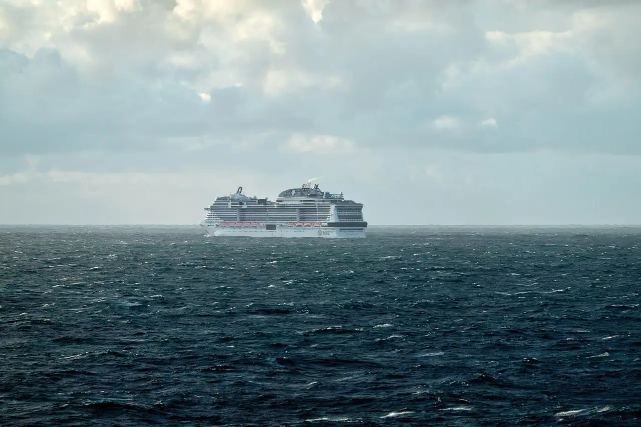 Cruise ship on the open sea under a cloudy sky